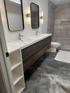 A modern bathroom renovation with a floating double vanity, sleek mirrors, and tiled shower by Enjaycee Unlimited in Cincinnati, OH.
