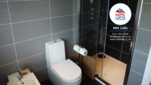 A modern bathroom installation featuring grey tiles, a toilet, bidet, and shower by MPK Conversions & Construction Ltd in Bristol, UK.