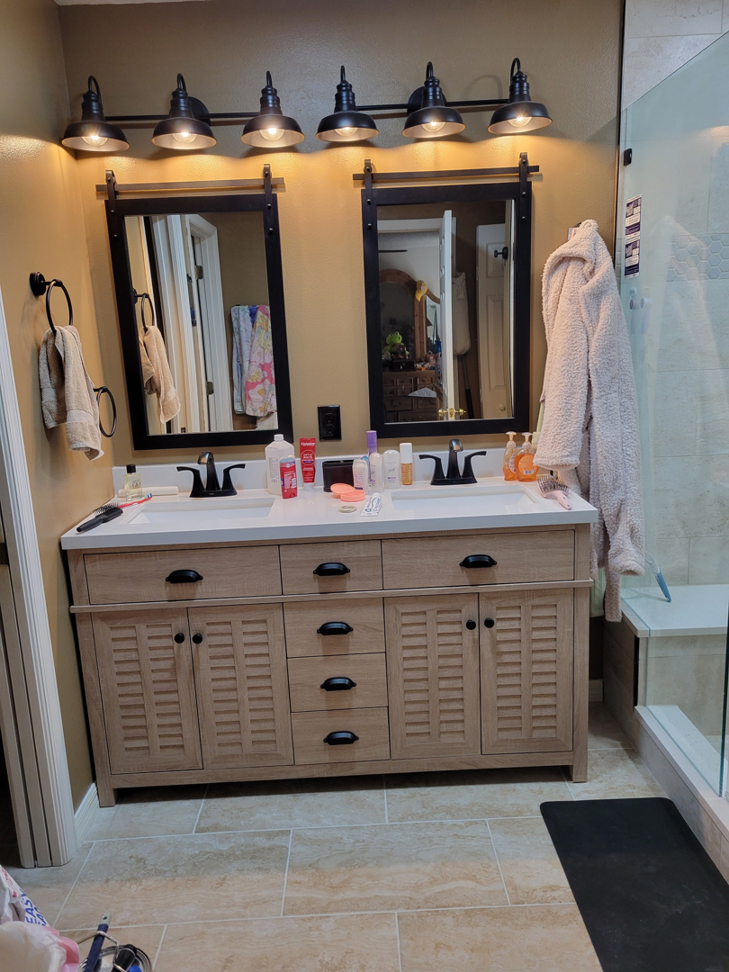 A modern bathroom remodel featuring a double vanity and new fixtures by Williams Custom Construction in Orlando, FL.