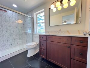 A modern bathroom remodel featuring a walk-in shower with geometric tiles by Dream Design Build & Remodeling, Inc. in Baltimore, MD