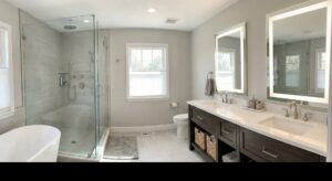 A modern bathroom remodel featuring a glass shower and double vanity by CM Home Contracting LLC in Charleston, SC.