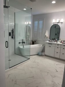 A modern bathroom remodel featuring a glass shower and freestanding tub by Jocia Construction Services in Gilbert, AZ.