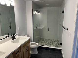 A modern bathroom remodel featuring a walk-in shower and double vanity by McDonald Custom Homes in Schenectady, NY.