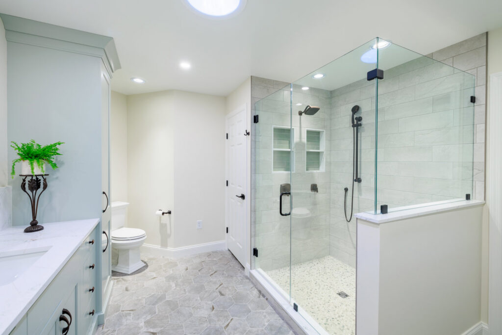 A spacious modern bathroom remodel with a glass walk-in shower and double vanity by Pluff Contractors LLC in Lancaster, PA.