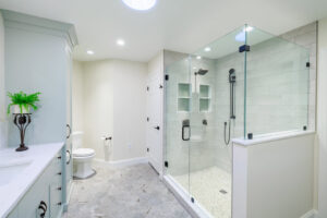 A spacious modern bathroom remodel with a glass walk-in shower and double vanity by Pluff Contractors LLC in Lancaster, PA.