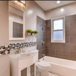 A modern bathroom remodel featuring new tiling, vanity, and fixtures by Revival Home Remodeling in Chicago, IL.
