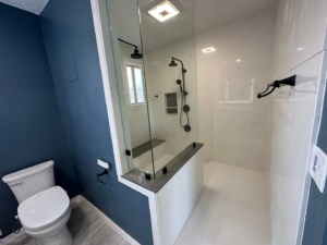 A newly remodeled modern bathroom featuring a glass shower enclosure and toilet by DSM Construction in Evanston, WY.