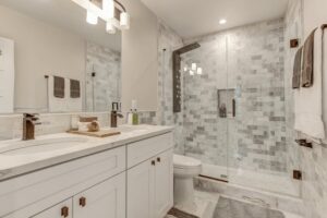 A modern, fully remodeled bathroom with a walk-in shower and double vanity by SRP construction in Houston, TX