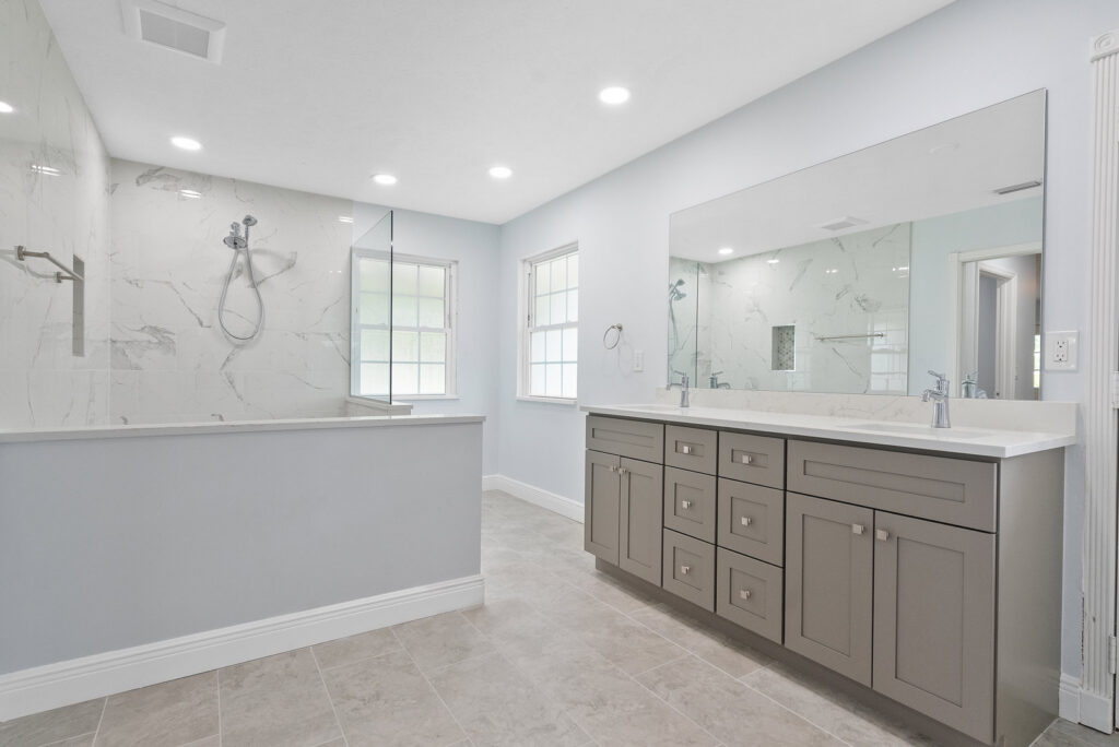 A spacious and modern bathroom remodel featuring a walk-in shower and a double vanity, completed by Stormtroopers Home Improvement in Port St. Lucie, FL.