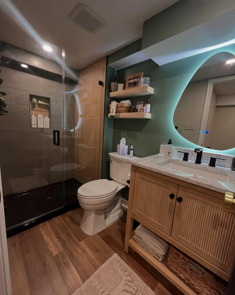 A modern bathroom remodel featuring a new vanity, lighted mirror, and glass-enclosed shower by Chesapeake Premier Remodeling in Baltimore, MD