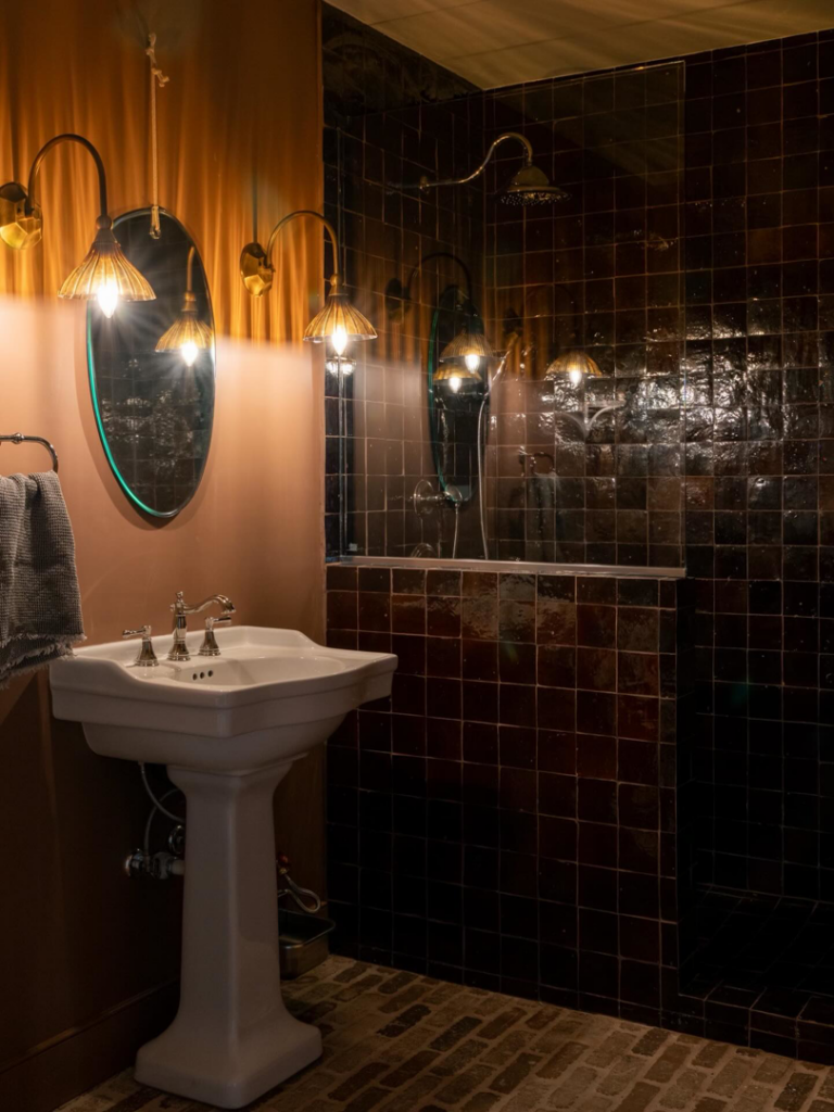 A beautifully renovated modern bathroom featuring a pedestal sink and tiled shower by Brentwood Builders Inc. in Lancaster, PA.