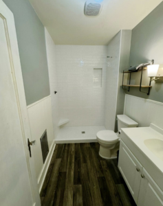 A modern renovated bathroom with white subway tile shower and new vanity by Burrell Tile INC in Cottage Grove, OR.