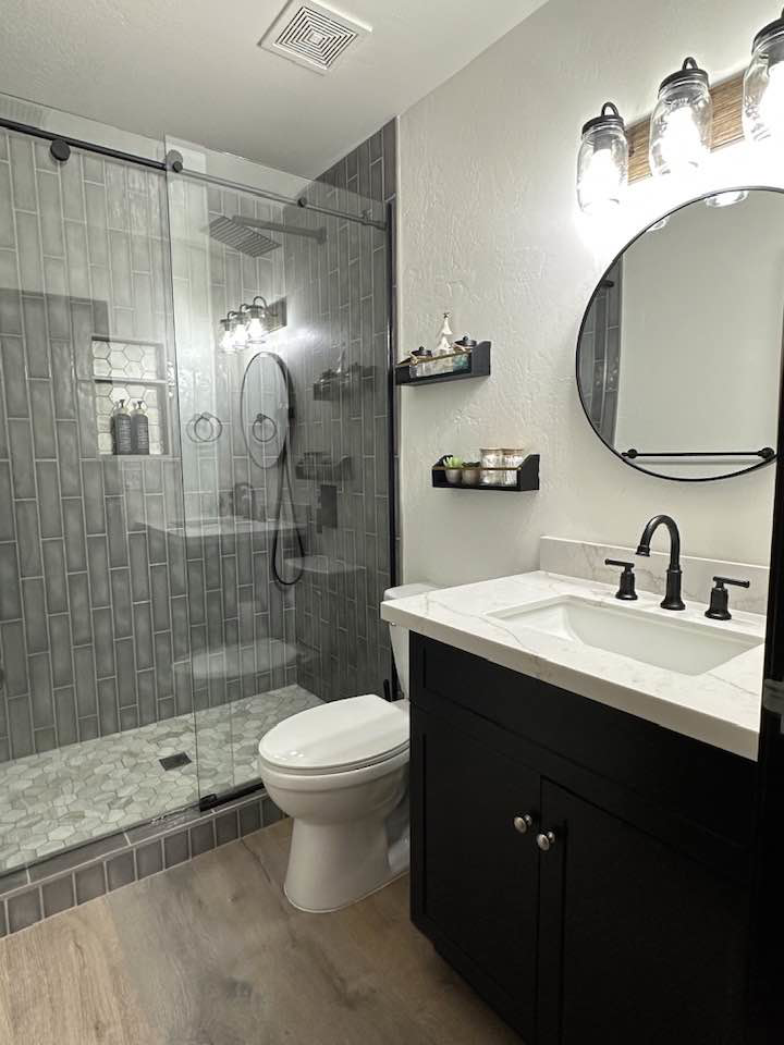 A newly renovated modern bathroom with a walk-in shower and new vanity by Eminent Renovations in Phoenix, AZ.