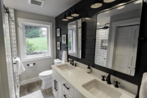 A modern bathroom renovation with a double vanity and black shiplap wall by Gordon T. Jacob in Tacoma, WA