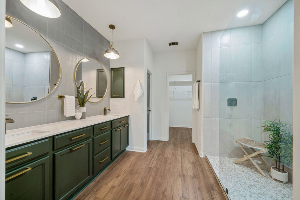 A newly renovated modern bathroom with a double vanity and walk-in shower by HomeNovate in San Antonio, TX.