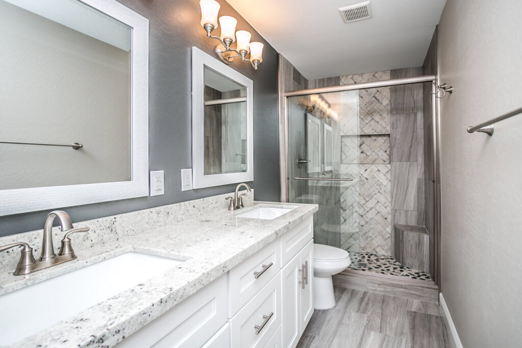 A modern bathroom renovation with a double vanity and walk-in tiled shower completed by Ignite Construction in Tempe, AZ.