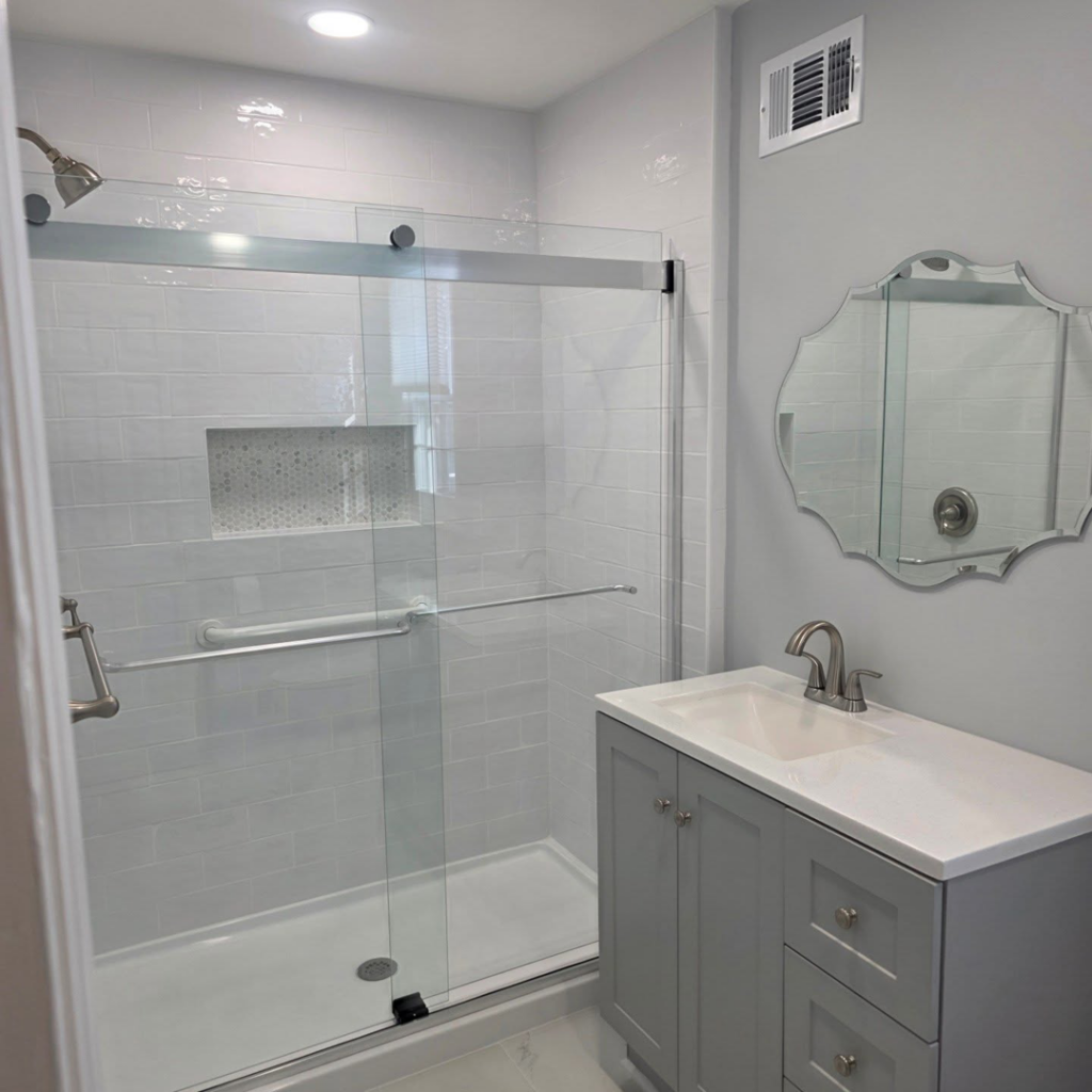A newly renovated modern bathroom featuring a glass shower enclosure and a stylish vanity by Noble Home Improvements in Edison, NJ.