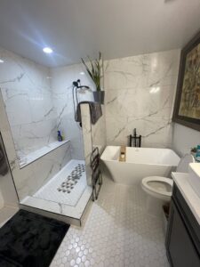 A modern bathroom renovation featuring a walk-in shower, freestanding tub, and hexagon tile floor by Donaldson & Company Construction in Charlotte, NC.