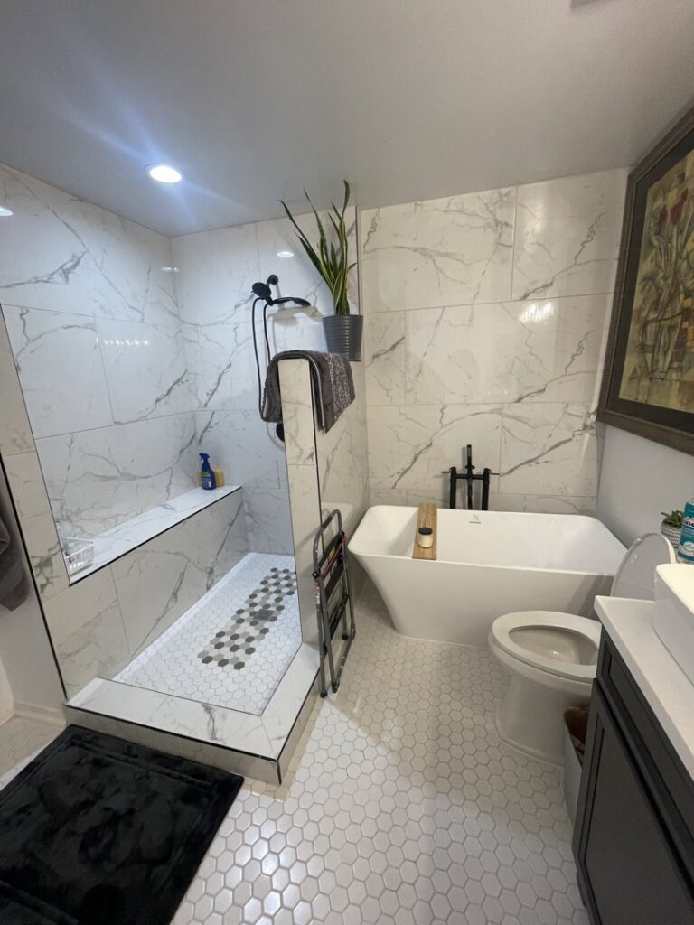 A modern bathroom renovation featuring a walk-in shower, freestanding tub, and hexagon tile floor by Donaldson & Company Construction in Charlotte, NC.