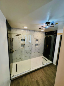 A modern bathroom renovation featuring a spacious walk-in shower with marble-look tiles by Dr.House in Orlando, FL