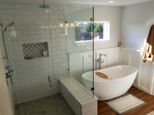 A beautifully renovated modern bathroom featuring a walk-in shower and freestanding tub by Kalau Builders LLC in Eugene, OR.
