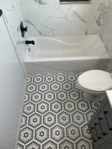 A modern bathroom renovation featuring hexagonal floor tiles and a new bathtub by Capital T's Home Specialty LLC in Topeka, KS.
