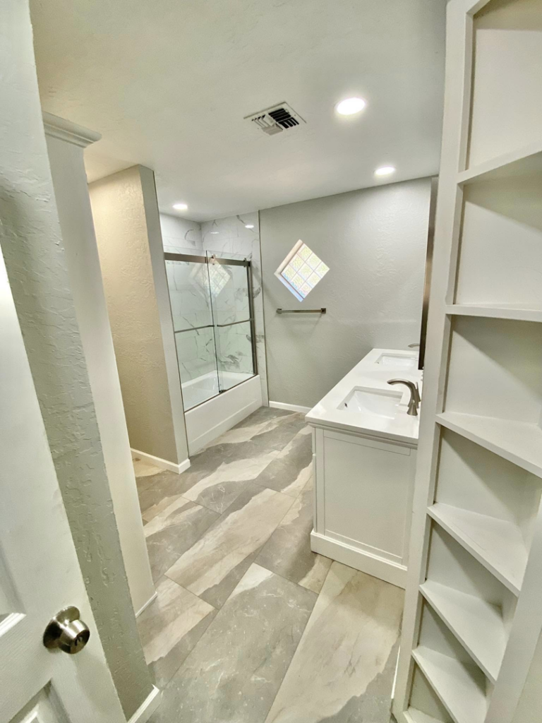 A modern bathroom renovation showcasing a new vanity, shower, and flooring by Cutting Edge Carpentry & Construction in Lawton, OK.