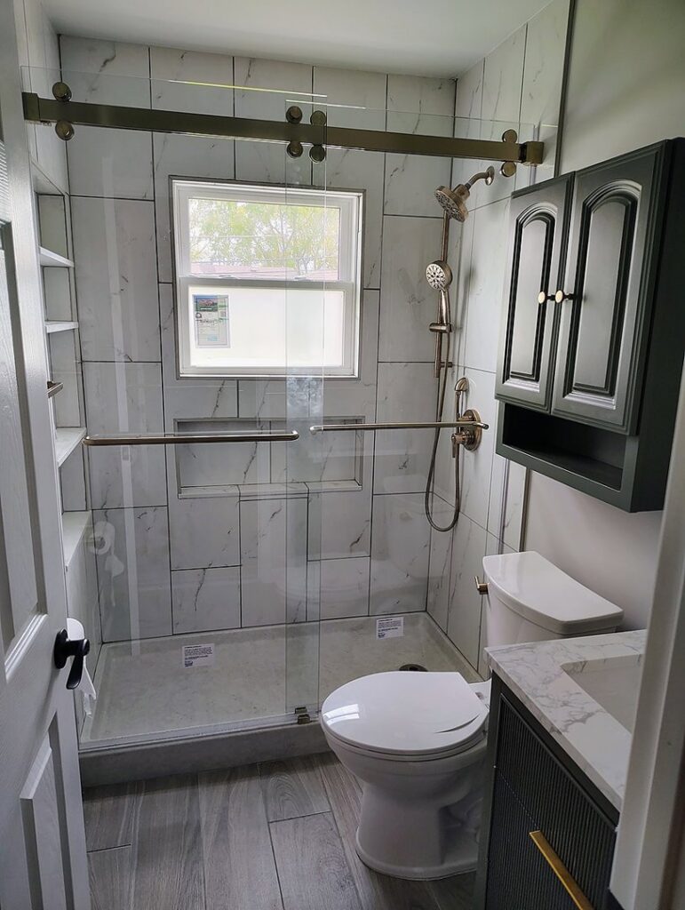 Modern bathroom with a glass shower enclosure and new fixtures installed by APS Residential Services in Livonia, MI.