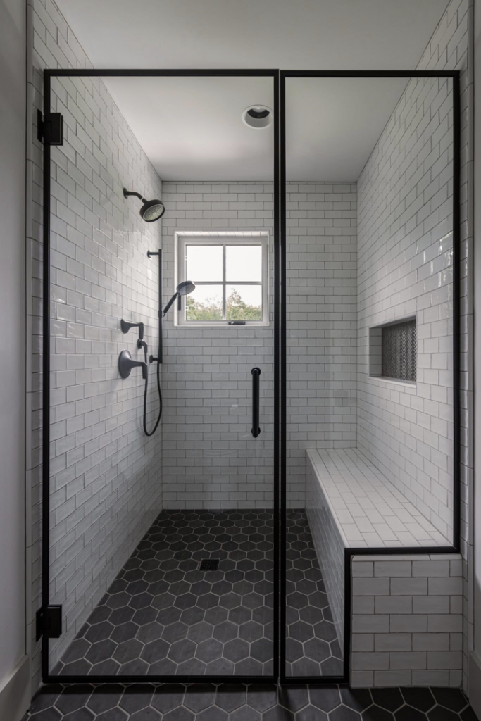 A newly installed modern bathroom shower with white subway tiles and black-framed glass doors by Kyle Build in Chattanooga, TN.