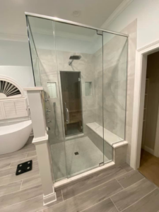 A modern glass-enclosed shower with tile walls and a bench, part of a bathroom remodel by Strom Contracting LLC in Crystal Lake, IL.