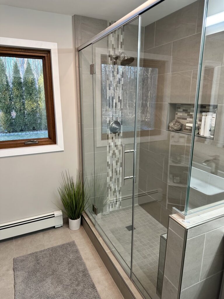 Modern bathroom shower remodel with glass enclosure and tile work by Top Notch Contracting in Racine, WI.