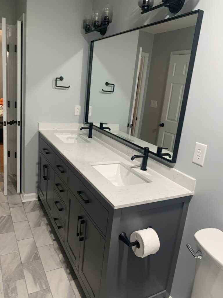 A modern bathroom featuring a double-sink vanity with black fixtures and a large mirror, installed by Huff Consolidated Enterprises LLC in Clarksville, TN.