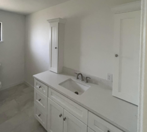 A newly installed modern bathroom vanity with white cabinets and a sink by D.R. Construction in El Paso, TX.