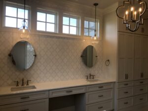 A newly installed modern bathroom vanity with dual sinks, mirrors, and pendant lighting by Specialty Service Group in Knoxville, TN.