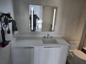 A modern bathroom vanity with a new sink and a lighted mirror installed by Just-In-Time Handyman Services in Honolulu, HI.