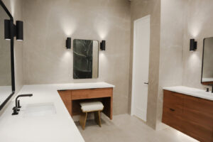 A modern bathroom remodel featuring a long vanity with a dedicated makeup area and grey marble-look tiles by Whole House Remodel & Design North Dallas Tx in Frisco, TX.