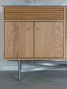 A modern wooden bathroom vanity with a sleek marble countertop installed by JDI Construction in Vancouver, WA.