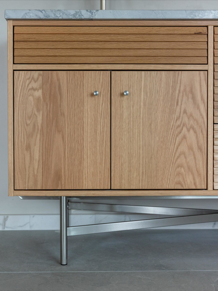 A modern wooden bathroom vanity with a sleek marble countertop installed by JDI Construction in Vancouver, WA.