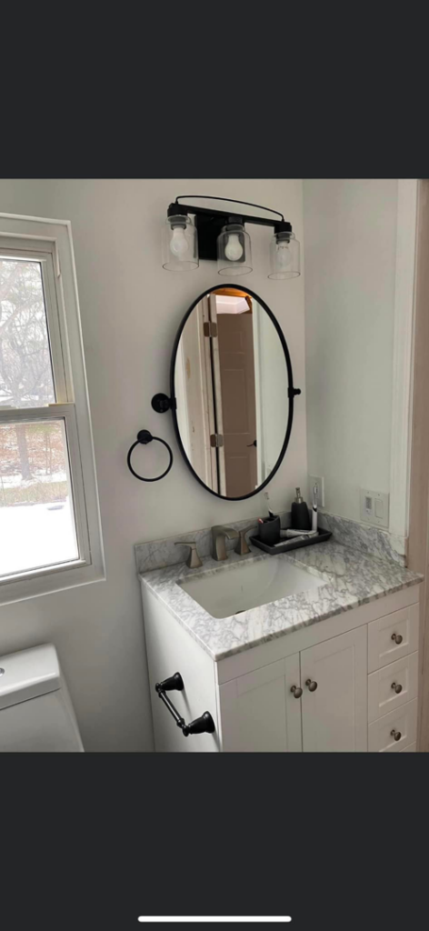 Modern bathroom vanity with sink, mirror, and light fixture by Do It All Contracting in Rochester, NY.
