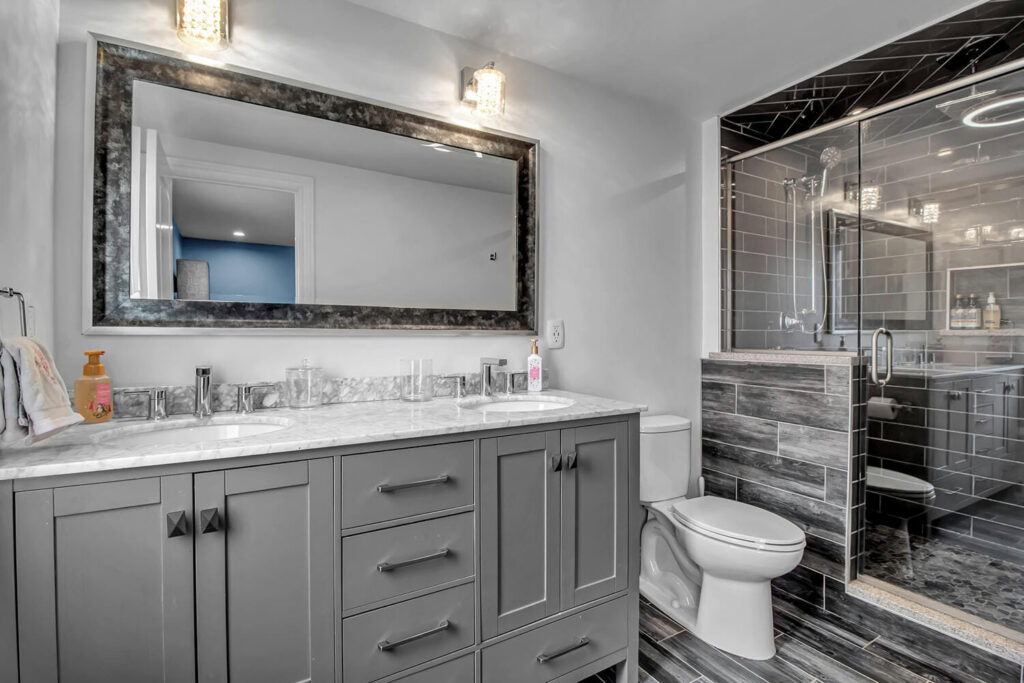 A modern bathroom renovation featuring a double vanity, large mirror, and a stylish walk-in shower, completed by Bob Build's WNY in Buffalo, NY.
