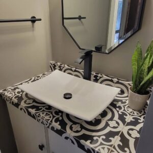 A modern bathroom vanity featuring a white vessel sink, patterned countertop tiles, and a sleek black faucet, installed by Blas Home Remodeling LLC in New Castle, DE.