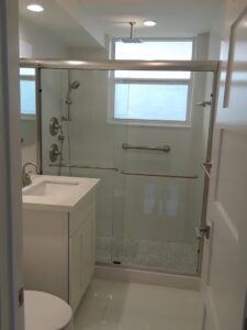 A modern finished bathroom with a walk-in shower and vanity by Corley Construction Inc in Fort Lauderdale, FL