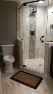Modern bathroom featuring a tiled walk-in shower and toilet, renovated by Tschida Construction in Cologne, MN.