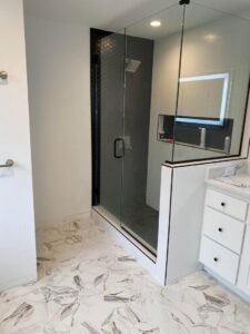 A modern bathroom featuring a glass shower enclosure and hexagonal floor tiles by CSR Tile Construction LLC in Minneapolis, MN.