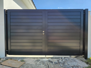 A modern black horizontal slat double gate installed by Aluminum Fence Contractor, Inc. in Hialeah, FL.