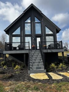A striking modern black house exterior with a multi-level deck and stairs by Technically Aesthetic General Contractors in Johnson City, TN.
