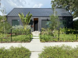 The exterior of a modern black house with a sleek metal roof, showcasing a completed project by Pioneer Built in St. Petersburg, FL.