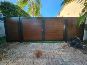 Modern brown and black horizontal slat double gate with side panels by Aluminum Fence Contractor, Inc. in Hialeah, FL.