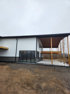 A modern building exterior with large windows and a covered patio, showcasing J and R Contracting's work in Buffalo, NY.