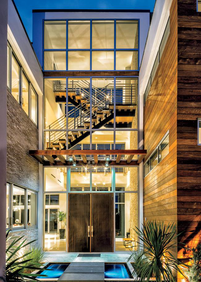 Modern building exterior with large windows and a visible staircase, showcasing a completed project by Plumb Partners LLC in Miami, FL.